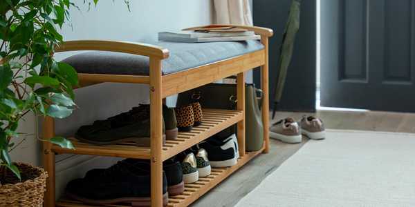 Wooden shoe storage bench with grey padded cushion.